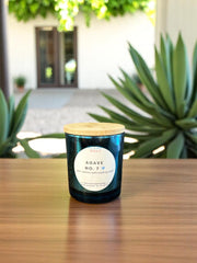Agave No. 7 5oz soy candle in jar with soft greenery in background